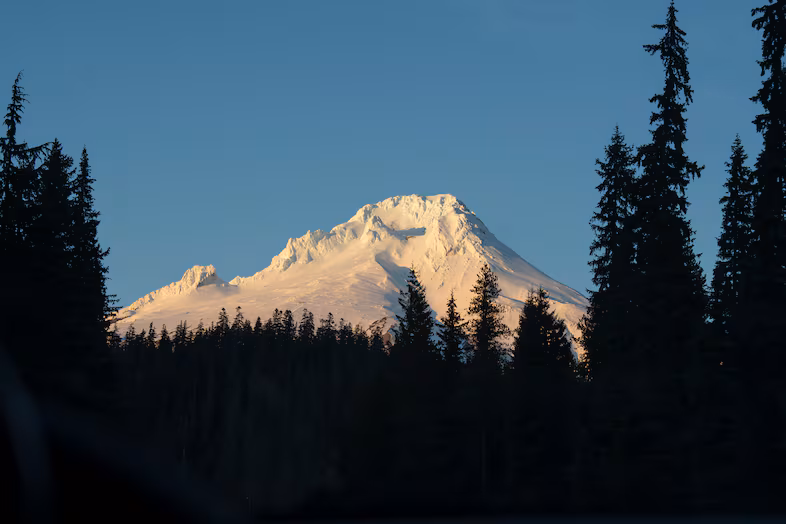 https://www.opb.org/article/2026/04/09/oregon-forest-protections-conservation-groups/Mount Hood and Mount Hood National Forest on Dec. 12, 2025. Mount Hood and Mount Hood National Forest on Dec. 12, 2025. Saskia Hatvany / OPB Before issuing sweeping protections on more than 30% of U.S. Forest Service-managed lands in 2001, federal officials spent more than a year holding 600 meetings across Western states and received more than 1.6 million public comments. But federal officials have not held a single public meeting since they announced in August an effort to terminate the 2001 Roadless Rule, which prohibits road construction, logging and mining on roughly 60 million acres of public land, including about 2 million acres of forests in Oregon. Forest Service officials did not respond to questions from the Capital Chronicle Thursday morning. Instead, U.S. Rep. Andrea Salinas — a Democrat representing Oregon’s Willamette Valley and ranking member of the House Agriculture Committee’s forestry subcommittee — and several conservation groups led by the Oregon chapter of the Sierra Club are taking up the mantle. Salinas and the Sierra Club hosted a public meeting Wednesday at the Ecotrust building in Portland, where roughly 60 audience members could give verbal comments or submit written ones. It was one of three public meetings on the Roadless Rule they scheduled this month, including a Monday meeting in Bend with roughly 150 attendees, according to organizers, and another scheduled for April 14 in Eugene. Related: What the reorganization of the U.S. Forest Service will mean for the Pacific Northwest The U.S. Department of Agriculture has so far opened a single three-week comment period since its leader, Brooke Rollins, proposed terminating the rule in August. Salinas told the audience a second comment period would open soon. The first public comment period brought in more than 600,000 comments, most of which expressed opposition to any rollback of the Roadless Rule. “Our next opportunity for public comment will open any day now, and I will again use this opportunity to demand this administration change course,” Salinas said. Last summer, she introduced the Roadless Area Conservation Act to enshrine the rule in federal law, but it does not yet have enough support to pass. In the House, 78 of her colleagues have signed on as co-sponsors, including Oregon Democratic Reps. Suzanne Bonamici, Janelle Bynum and Maxine Dexter, as have 25 U.S. Senators. The state’s two other representatives, Democrat Val Hoyle and Republican Cliff Bentz, have not signed on as sponsors. What roadlessness protects Roadless areas in Oregon include Iron Mountain in the Willamette National Forest, Joseph Canyon in Wallowa County, Tumalo Mountain in central Oregon and Lookout Mountain in the Ochoco National Forest. Jared Kennedy, who works for the Greater Hells Canyon Council in Enterprise, said at Wednesday’s meeting there are already 26,000 miles of roads across Forest Service lands in eastern Oregon, southeast Washington and north-central Idaho. “That’s more than enough miles of road to circle the Earth and then still drive to Portland from Enterprise and back,” he said. Some attendees had worked on passing the Roadless Rule and spoke at public meetings the Forest Service held in 1999 and 2000. Among them was Kristin Faulkner, who said issues that spurred the rule in the first place have only gotten worse, as climate change, declining snowpacks and biodiversity loss accelerate drought, floods and wildfire. “Here we are 26 years later, or six presidential terms later, or a generation later, to again defend why we desperately need the Roadless Rule to remain fully intact more than ever before,” she said. She and others argued that intact forests have far-reaching benefits, including keeping water clean for fish and humans. Nearly 90% of people in the West are served by public drinking water systems that rely on water from national forest and grasslands. Commenters also discussed the massive amounts of carbon forests take-in and store, and that would otherwise enter the atmosphere as gas, further increasing global temperatures and climate change. The largest roadless area in the U.S., the Tongass National Forest in Alaska, holds 44% of all the carbon stored by the United States’ national forests and is home to some of the last old-growth stands in the country. Related: US Forest Service to close Portland headquarters, research station, open Salem office A firefighter at the meeting discussed his concerns with more roads in forests given 85% of wildland fires are caused by humans, and 90% of those start within a half mile of roads, according to Forest Service data. Others discussed the already low funding and growing backlog of maintenance needs on existing roads in national forests. Jordan Latter, a manager at Bark, a conservation watchdog group dedicated to protecting the Mt. Hood National Forest, cited a recent Pew Charitable Trusts report showing a $6.4 billion road maintenance backlog within the National Forest system. He added that the roads in Mt. Hood alone need $72 million of investment to be brought up to standard. “And what is in the president’s fiscal year 2027 budget proposal? $73 million for road maintenance — for the entire National Forest system,” he said. Oregon Capital Chronicle is part of States Newsroom, a network of news bureaus supported by grants and a coalition of donors as a 501(c)(3) public charity. Oregon Capital Chronicle maintains editorial independence. Contact Editor Julia Shumway for questions: info@oregoncapitalchronicle.com. Follow Oregon Capital Chronicle on Facebook and Bluesky. This republished story is part of OPB’s broader effort to ensure that everyone in our region has access to quality journalism that informs, entertains and enriches their lives. To learn more, visit opb.org/partnerships.